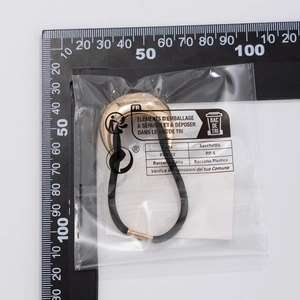 Detail of black elastic hair band with a polished gold crescent-shaped metal ornament