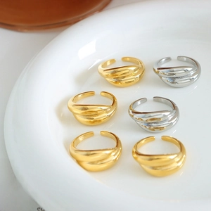 Set of 6 cross-layer open rings in gold and silver finish on a ceramic plate