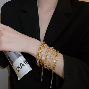 Detail of four-piece gold chunky chain bracelet set with pearl and OT buckle