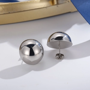 Detailed view of silver stainless steel half-ball stud earrings with butterfly backings