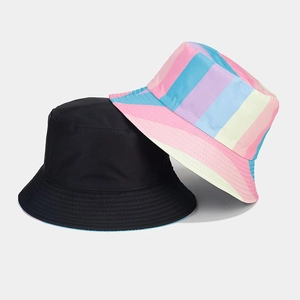 Detail of reversible bucket hat showing solid black and macaron rainbow striped patterns