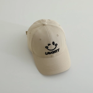 Detail of embroidered winking smiley face and LAUGHTY text on beige cotton baseball cap