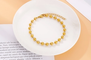 Detailed top view of a gold hollow bead titanium steel bracelet with lobster clasp