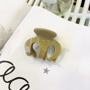 Detail of khaki resin hair claw clip with Barrette La France engraving on a magazine