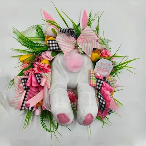 Close-up of Easter wreath with plush bunny, artificial flowers and Happy Easter sign