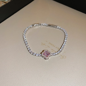 Detail of silver clover tennis bracelet with pink gemstone and sparkling zirconias