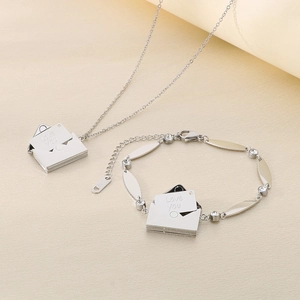 Dettaglio del ciondolo a busta d'argento con incisione Love You e bracciale con cristalli