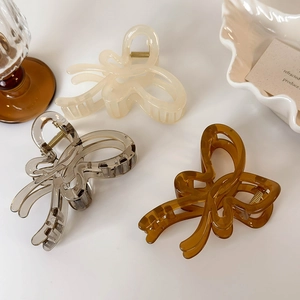 Close-up of butterfly hair claws in jelly colors, cream, grey and amber with metal spring