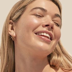 Elegant 18K gold-plated double-layered round hoop earrings shown on a model side profile