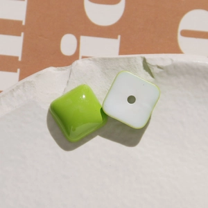 Detail of green and white square resin beads with smooth glossy finish for DIY jewelry