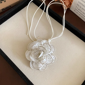 Detail of white 3D camellia flower choker necklace with sparkling beaded petal edges