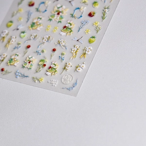 Close-up of 3D bunny fairy nail stickers with strawberry and daisy floral patterns
