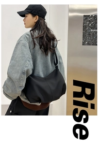 Close-up of black pleated dumpling shoulder bag with nylon texture on urban background