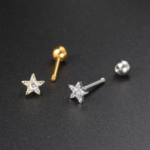 Macro shot of gold and silver star-shaped zircon ear studs with screw ball backs