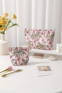 Detail view of two fabric makeup bags with embroidered palm trees and geometric patterns