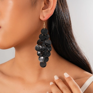 Detail of layered black sequin cluster drop earrings on model for a bold gothic style
