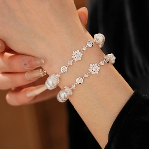 Détail de gourmette double couche en argent avec perles et charm flocon de neige en zircon