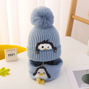 Detalle del conjunto de gorro y bufanda de punto azul claro para bebé con bordado de pingüino