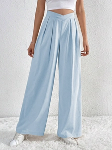 Detail of high-waist crossover waistband and textured light blue fabric on wide-leg pants