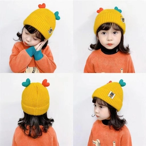 Close-up of yellow knit baby hat featuring 3D colorful heart accents and soft textures