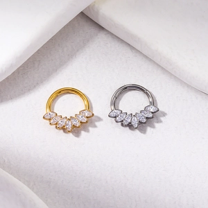 Close-up of F136 titanium rings in gold and silver finish with marquise zircons