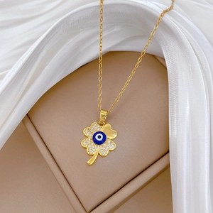 Detail of clover evil eye necklace with crystals on elegant white silk background