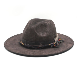 Detail of vintage wool fedora hat featuring ethnic ribbon and metal feather ornament