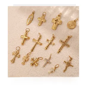Flat lay of vintage gold cross pendants with intricate engravings on white textured fabric