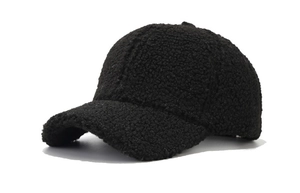 Detailed close-up of a black fuzzy lamb wool baseball cap showing warm plush texture