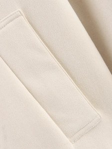 Close-up of beige suede jacket showing high-quality stitching and soft fabric texture