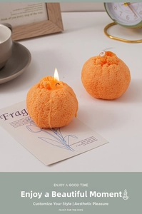 Detalle de velas con forma de naranja con textura de fruta realista y mecha encendida