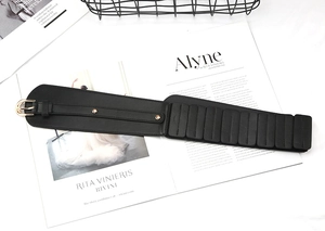 Close-up of black PU leather corset belt with gold metal buckle and elastic band details