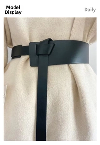 Detail of minimalist black PU leather waist belt with stylish knot design on cardigan