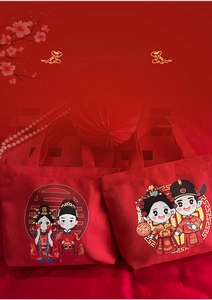 Close-up of red wedding canvas tote bags with cartoon bride and groom illustration