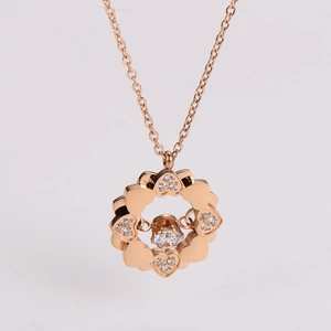 Detail of rose gold clover pendant necklace featuring sparkling diamonds and heart shapes