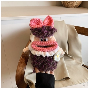 Detailed view of hand-knitted purple doll shoulder bag with pink bow and floral accents