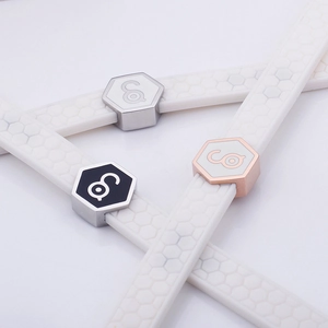 White silicone honeycomb sport bracelet with black, silver, and rose gold metal clasps