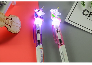 Detail showing glowing LED unicorn pens in purple and pink with illuminated light effect