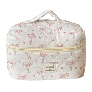 Quilted cotton travel makeup bag with pink bow and floral patterns on white base