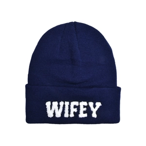 Close-up of navy blue knit beanie featuring white fuzzy WIFEY letter embroidery details