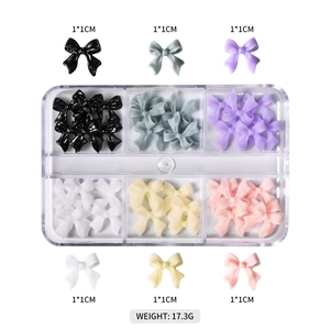 Detail view of 3D resin butterfly nail art charms in a 6-grid transparent storage box