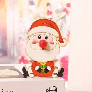 Dettaglio decorazione natalizia in legno di Babbo Natale con naso rosso e regalo