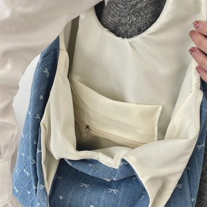 Détail intérieur du sac en jean avec doublure en tissu écru et poche zippée pratique