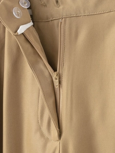 Detailed close-up of khaki twill trousers featuring double button closure and zipper fly
