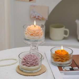 Set candele profumate a forma di peonia in ciotole di vetro trasparente su tavolo