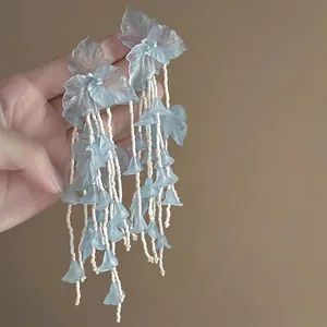 Detail of light blue floral tassel earrings with beaded fringe for summer beach style