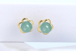 Macro shot of gold flower earrings featuring natural green stone petals and metal base