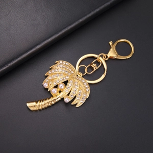 Détail d'un porte-clés palmier doré avec strass et perles sur cuir noir élégant