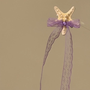 Detailed view of a starfish hair clip with a purple lace bow and long elegant ribbons