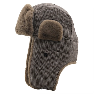 Detail of herringbone trapper hat with thick brown faux fur lining and ear flaps